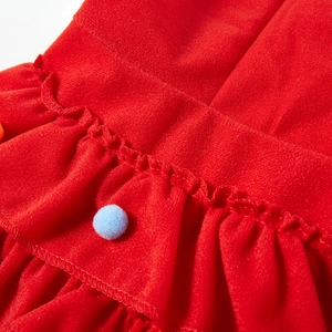 Detail of red pet Christmas cloak showing ruffled hem and soft blue pompom ornament