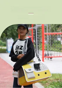 Yellow and white pet carrier with cat-ear window shown in an outdoor park setting