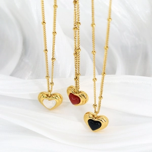 Three heart pendant necklaces in gold finish with black red and white shell inlays