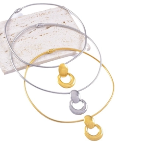 Sleek gold and silver snake chain necklace set with U-shaped pendants on marble