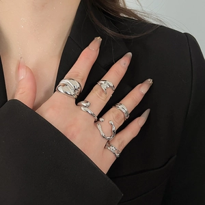 Close-up of 6-piece silver ring set featuring smooth, twisted, and geometric textures on hand