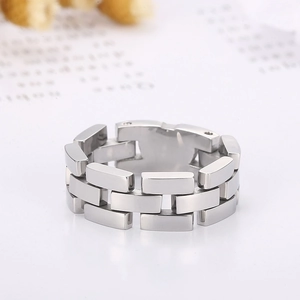 Detail shot of silver stainless steel watchband-style ring chain link on a white surface
