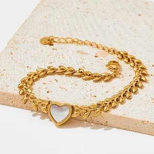 Detail view of golden heart shell bracelet with leaf chain and lobster clasp closure
