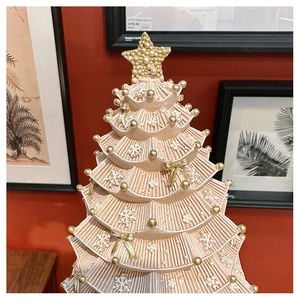 Close-up of vintage pink Christmas tree music box with gold pearls and snowflake relief