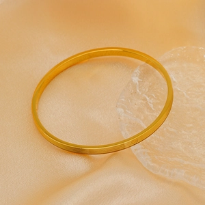 Detailed view of gold plated titanium steel bangle with elegant horizontal textures