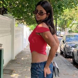 Outdoor street style view of a red slim fit cropped T-shirt with ruched detailing