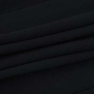 Gros plan sur un tissu noir texturé avec un drapé élégant et des transitions d'ombre douces