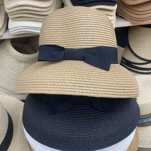 Close-up of fine woven straw sun hat texture with decorative ribbon bow details