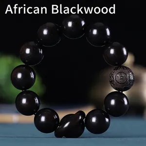 Détail macro de perles en bois noir africain avec gravure de tortue dragon et grain lisse