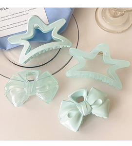 Detail of cream blue bow and star hair claws in high-quality acrylic on a desktop