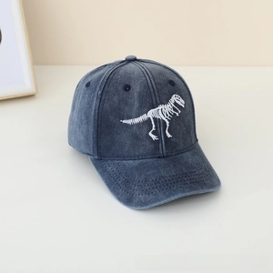 Detail van wit dinosaurus skelet borduurwerk op een donkerblauwe gewassen denim pet