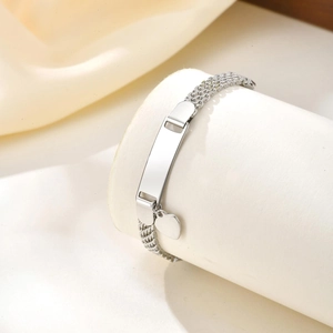 Macro shot of silver stainless steel ID bracelet with engravable plate and heart charms