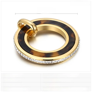 Détail d'un pendentif rond de 41 mm en acier inoxydable doré avec résine et strass brillants