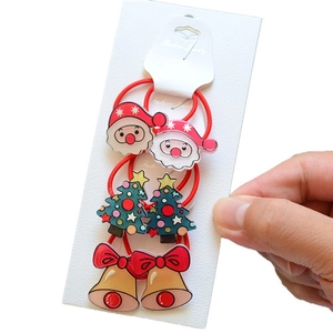 Detailed view of Christmas hair ties featuring Santa Claus and tree charms on a card