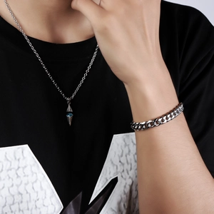 Close-up of a silver necklace with blue gemstone pendant and matching Cuban bracelet