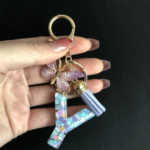 Close-up of resin letter Y keychain with colorful heart sequins and butterfly charm