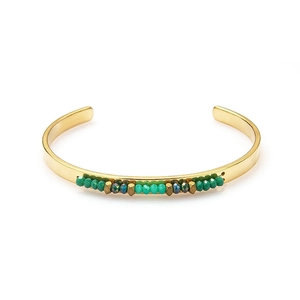 Detail of gold open cuff bracelet featuring turquoise beads and metallic spacers