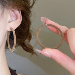 Detailed view of coffee brown velvet flocked hoop earrings with elegant matte texture