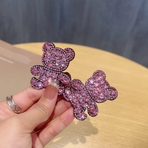 Detail of pink rhinestone bear hair clips showing shiny texture and cute aesthetic design