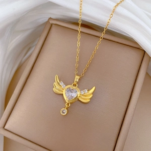 Close-up of gold titanium heart necklace with angel wings and sparkling rhinestones