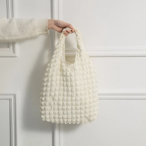 Detail shot of ivory bubble textured fabric and soft handle on a stylish waffle tote bag