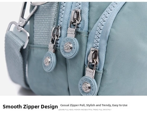 Detail view of light blue nylon bag with three metal zippers and BOBO brand pullers