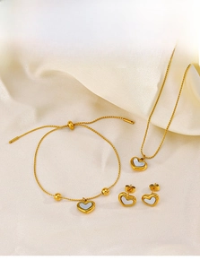 Detail shot of heart jewelry set with shell inlays on silk fabric display