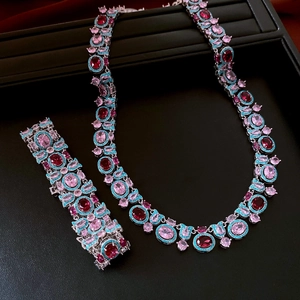 Dettaglio parure vintage con pietre ovali rosa e piccoli zirconi blu su base argento