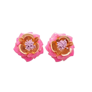 Boucles d'oreilles fleur rose et or élégantes avec perles violettes sur fond blanc