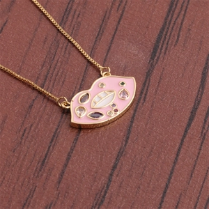 Golden box chain necklace with a pink enamel lip pendant and colorful rhinestones