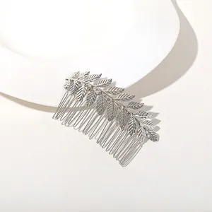 Close-up of silver metal leaf hair comb with intricate leaf design and ten comb teeth