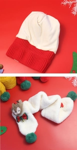 Detail of red and beige knit hat with reindeer scarf and bell accents for Christmas