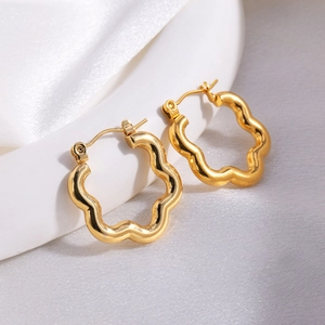 Detailed view of asymmetric golden flower earrings with a polished metallic finish