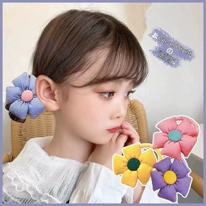 Detail of colorful fabric flower hair ties for girls in soft pastel macaron colors
