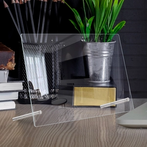 Detail shot of a transparent acrylic desktop planner board with metal support legs
