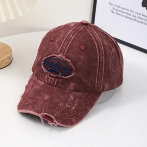 Gros plan d'une casquette vintage rouge délavée avec broderie NEW YORK et détails usés