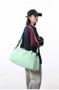 Mint green large capacity sports gym and travel bag shown on female model in studio.
