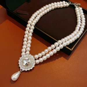 Detail of double-layer pearl necklace with square crystal pendant in jewelry box
