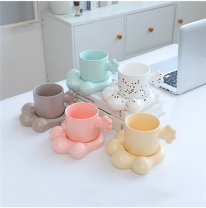 Macro shot of creative ceramic cat paw mugs and saucers in five assorted colors