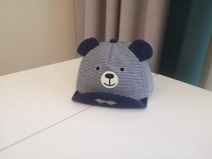 Detail of blue and white striped baby hat with 3D bear ears and embroidery textures