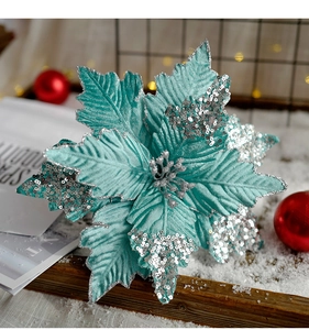 Detailed macro shot of teal velvet Poinsettia flower with silver glitter and sequins