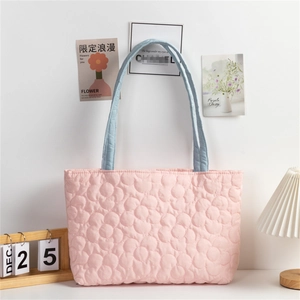 Detail of pink floral quilted tote bag with contrasting light blue woven shoulder straps