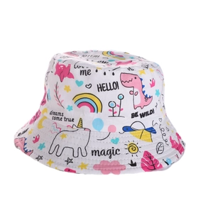 Dettaglio cappello alla pescatora in cotone bianco con stampe di dinosauri e unicorni