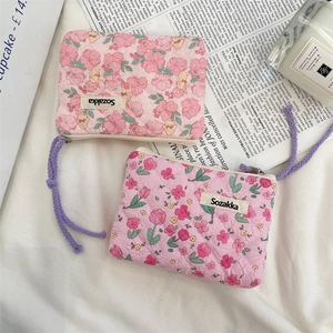 Detail of pink quilted floral pouches with purple knot straps and premium fabric texture