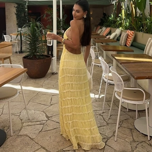 Detail of yellow backless pleated maxi dress with elegant tiered ruffle design for summer