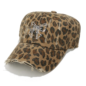 Détail de casquette léopard avec nœud en strass et bords effilochés au style vintage