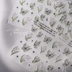 Macro detail of 3D embossed butterfly and lily of the valley floral nail art stickers