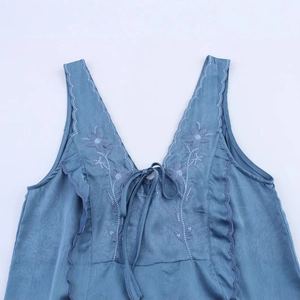 Robe bleue sans manches à col en V avec broderie florale et détails de liens à nouer