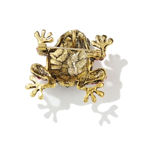 Détail macro de broche grenouille dorée montrant les textures et l'attache épingle