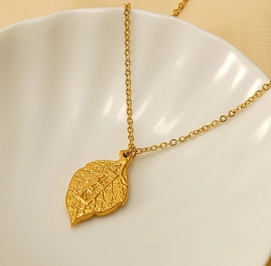 Detail of gold leaf pendant necklace with Chinese characters for wealth on white shell